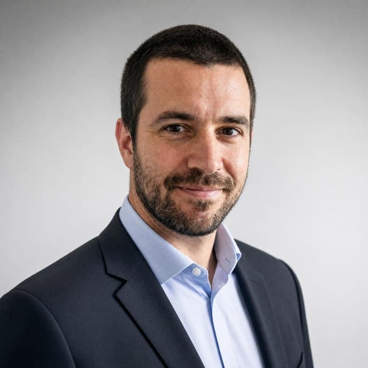 The same person as a corporate headshot: suit and studio backdrop